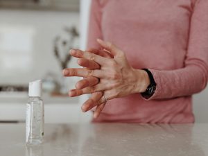 Woman using hand sanitizer in kitchen